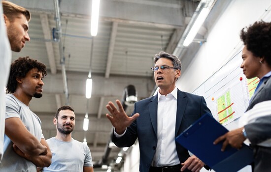 Company leader talking to the employees while visiting a factory.